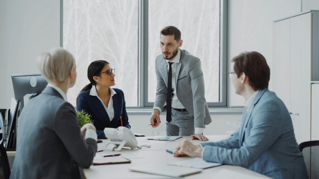 Professionals engaged in a serious business discussion in a bright office environment.